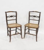 Pair of cane seated side chairs with turned and carved top rails, carved and pierced and turned