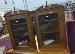 Pair of 20th century oak wall-hanging corner display cabinets, the broken arched pediment above