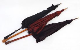 Three late 19th/early 20th century parasols, one with turned ebonised handle with a silver-