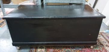 Black stained trunk on plinth base raised on casters