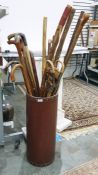 Group of walking sticks, canes and a shooting stick in a leather-bound stand