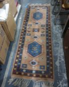Wool rug of geometric design in blue and pink  218 x 74 cms