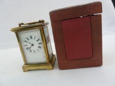 Brass carriage timepiece in plain case, with red leather-bound travelling case, 15cm high
