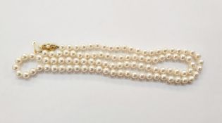 String of cultured pearls with 18ct gold bow-pattern clasp set with single pearl, 75cm long