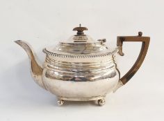 Silver teapot of plain form, with gadrooned border, raised on ball feet, London 1918, length 28cm,