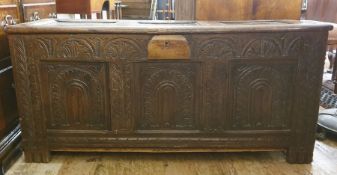 18th century oak coffer, the three-panelled top with moulded stiles, lunette carved front, with