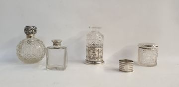 Silver-topped scent bottle with cut glass ovoid body, scrolling foliate lid, a silver engine-
