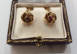 Pair gold-coloured knot, torpedo and chain cufflinks, each knot set with single cabochon ruby,