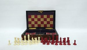 Figured walnut and brass-bound games box, rounded oblong and fitted with bone chess pieces, counters