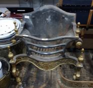 Elaborate fire grate with a curved serpentine decorated front, on brass supports, the curb showing a