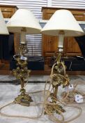 Pair of brass table lamps, each decorated with three flowerheads and leaves on a foliate tripod