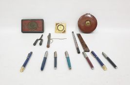 Assorted items to include pens, a South African 1900 Queen Victoria tin box, thermometer, clock, etc