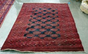 Bokhara type rug with black ground central field, decorated with hooked elephant foot guls, on a