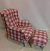 A contemporary wing back armchair and matching foot stool