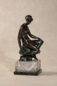 A bronze model of a seated female nude