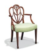 A George III carved mahogany shield back armchair, possibly by Gillows, in the manner of