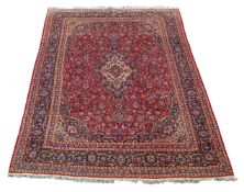 A Mashad carpet, North-East Persian, the vermillion central field decorated throughout with floral