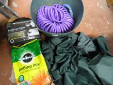 Tub Containing Hose Pipes, Potting Mix, and Barbec