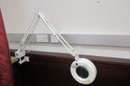 Three illuminated magnifiers on articulated spring arm