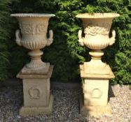 PAIR WHITE CAST IRON URNS ON PLINTH