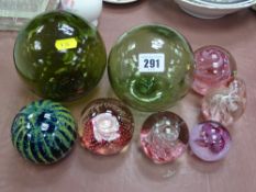 Two green glass fishing net floats and a collection of vintage paperweights