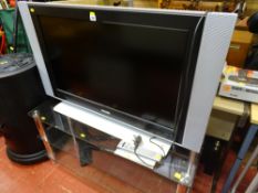 Large screen Phillips TV and three shelf glass stand E/T