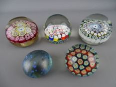 Four millefiori cane glass paperweights by Murano, Italy etc and an Isle of Wight iridescent glass