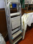 Two non-matching metal stepladders and two matching plastic folding chairs