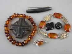 Two amber bracelets and a sterling silver mouse brooch, a horn cross brooch and three bog oak/jet