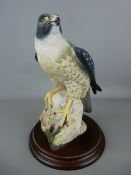 Country Artist's figurine of a falcon on a circular wooden base