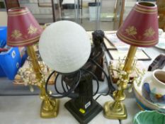 Bronzed effect table lamp in the form of an Art Deco figurine holding a globular shade and a pair of