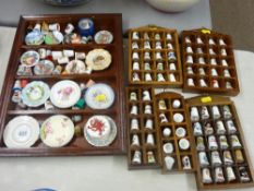 Collection of china thimbles and miniature wall plates in display units