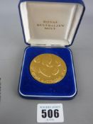 Cased Royal Australian Mint gold colour coin showing indigenous animals and Aborigine in relief