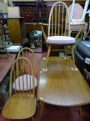 Ercol mid oak twin flap dining table and seven (four plus three) spindleback light wood dining