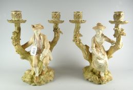 A pair of Royal Worcester figural twin candle holders in the form of lady and gentleman seated on