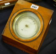 A late nineteenth century brass encased circular dial barometer by C W DIXEY in a glazed oak case