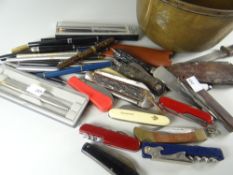 A brass pan containing pens, pen knives ETC Condition reports are provided on request by email