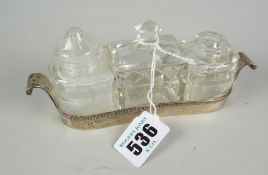 A gondola-shaped silver three-bottle condiment dish Condition reports are provided on request by