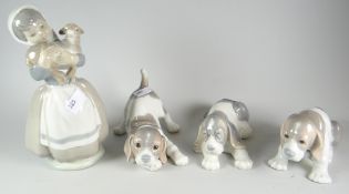 A Nao figure of a girl with lamb & three Lladro puppies Condition reports are provided on request by