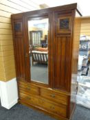 A vintage single door mirrored wardrobe with carved panels & three base drawers