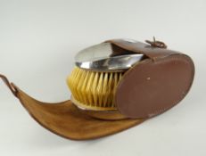 A pair of concave silver monogrammed gentleman's brushes in a brown leather case, initialled C H B