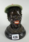 A nineteenth century bronze blackamoor bust of a bearded man with painted lips & marble eyes, having