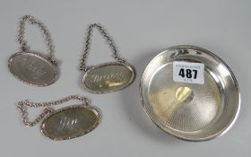 A small silver dish & three oval silver wine labels for brandy, whisky & gin, 2.9oz. total Condition