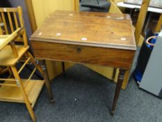 A nineteenth century mahogany sloped ship's desk on turned supports, the top hinging to reveal a