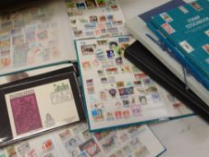 Two albums of first day covers, five green WH Smith albums of stamp stock, a blue folder of