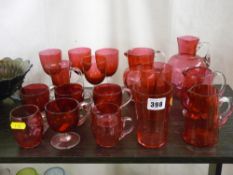 Four cranberry glass jugs, a quantity of custard cups and other cranberry glassware