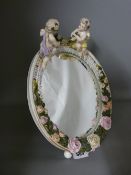 Continental porcelain easel mirror with cherub and floral decoration, 32 cms high