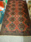 Old Baluchi rug, bold red central pattern on a deep blue ground, 197 x 108 cms