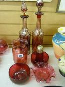 Two ruby red facet cut decanters and five pieces of cranberry glassware