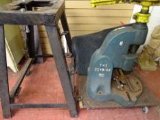 Heavy metal press with embossed title 'The Denbigh Six' along with mobile metal stand